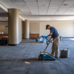 Man using machine to pull up high pile carpeting in an office space