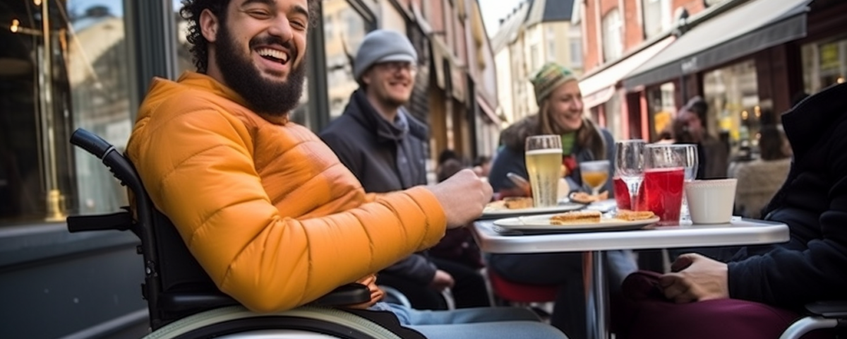 Man in wheelchair sitting at outside table at a bistro