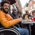 Man in wheelchair sitting at outside table at a bistro