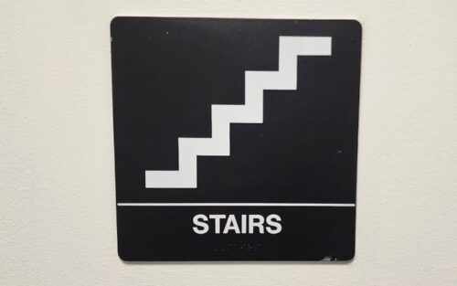 Sign for a stairwell that has braille and raised characters
